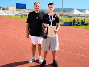 Ο μαθητής του 5ου ΓΕΛ Μυτιλήνης Παναγιώτης Βαλσαμίδης με το χρυσό μετάλλιο, το κύπελλο και το δίπλωμά του, μαζί με τον πατέρα του.